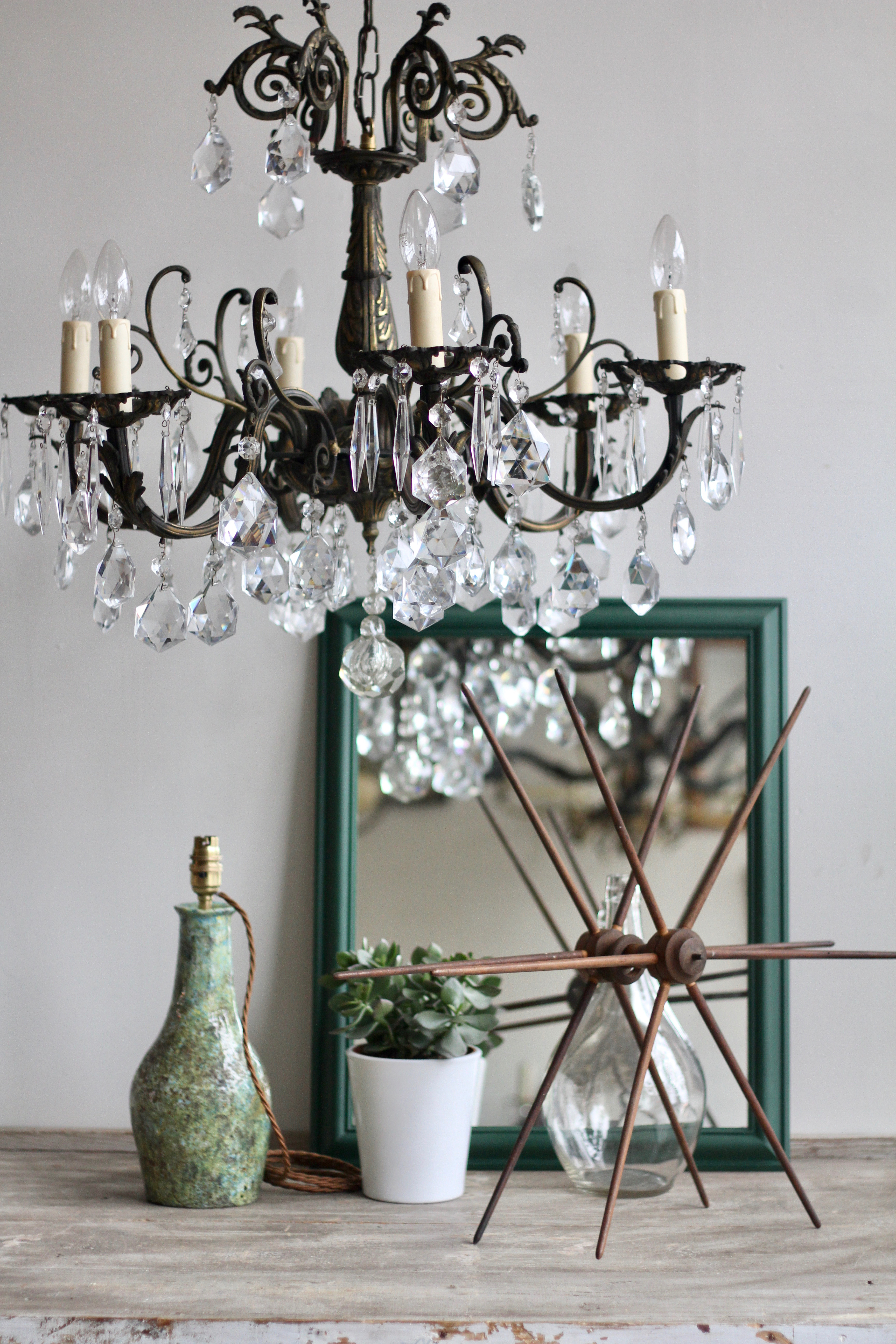 Shop Styling. Ornate Brass Chandelier with Annie Sloan painted Mirror, Textile Swift and Pottery Lamp.